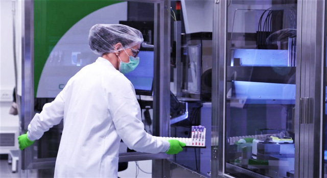 Một nhân viên tại trụ sở của BioNTech ở Mainz, Đức đưa mẫu bệnh phẩm của bệnh nhân vào phòng thí nghiệm.